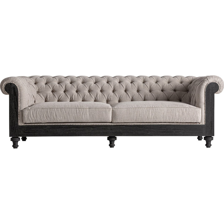Divano Colonial Luxury in lino beige con struttura in legno nero e lavorazione capitonné.